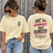 Woman wearing the butter yellow Not Abandoned Just Redirected oversized Christian tee, front with Still His chest print and back with Hebrews 13:5 print